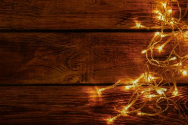 Ahşap arka planda ışıltılı ışıklar, üst manzara. Metin için boşluk