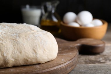 Fresh yeast dough with flour on wooden table, closeup. Space for text