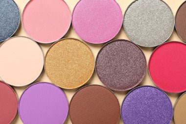 Different beautiful eye shadows on beige background, flat lay