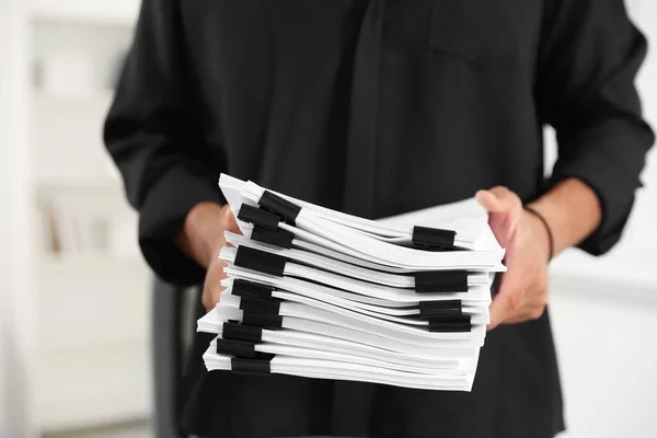 Businessman with documents in office, closeup view