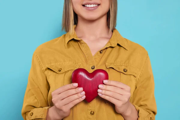 Young Woman Holding Red Heart Turquoise Background Closeup Volunteer Concept — Stockfoto