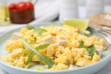 Plate with delicious scrambled eggs, tofu and lime, closeup