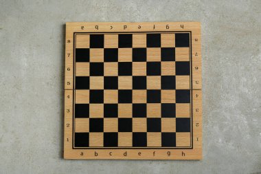 Empty wooden checkerboard on light grey table, top view