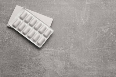 Blister with chewing gums on light grey table, top view. Space for text