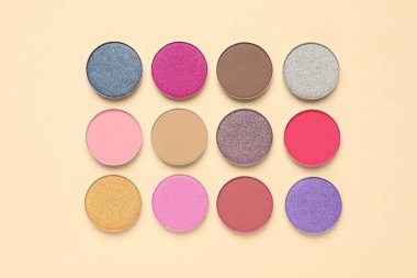 Different beautiful eye shadows on beige background, flat lay