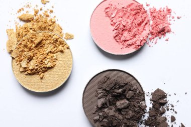 Different crushed eye shadows on white background, flat lay. Professional makeup product
