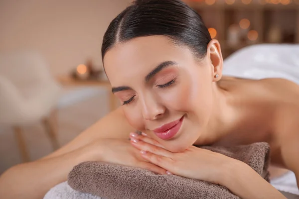Young woman resting on massage couch in spa salon, closeup