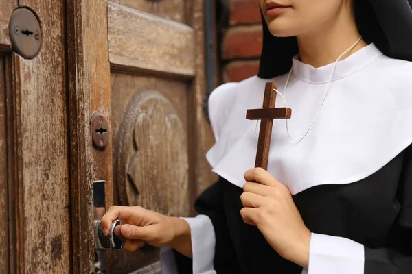Молода Черниця Християнським Хрестом Біля Дерев Яних Дверей — стокове фото