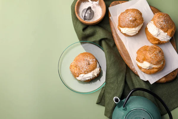 Delicious Profiteroles Filled Cream Teapot Green Background Flat Lay Space — Photo