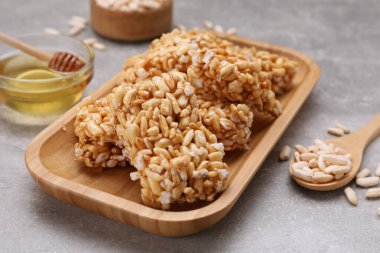 Plate with puffed rice pieces (kozinaki) on grey table