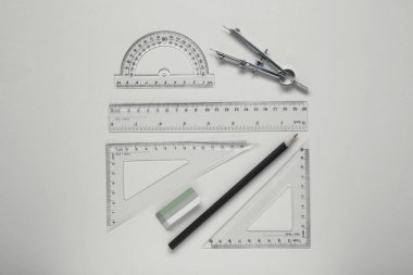 Flat lay composition with different rulers and compass on yellow background