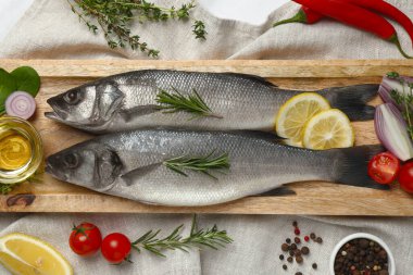Lezzetli levrek balığı ve malzemeler beyaz masada.