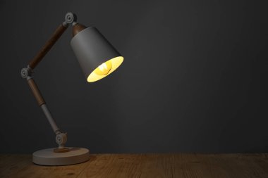 Modern masa lambası gece ahşap masada, metin için yer var.