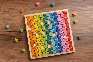 Colorful math game kit with arithmetical tasks on wooden table, flat lay