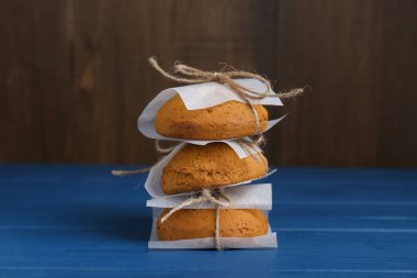 Stack of tasty oatmeal cookies on blue wooden table