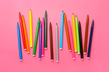 Many bright markers on pink background, flat lay