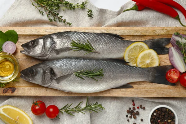 Lezzetli levrek balığı ve malzemeler beyaz masada.