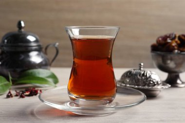 Tea in glass and vintage tea set on wooden table