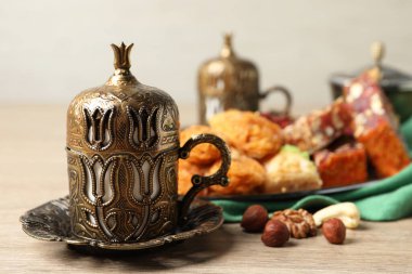 Tea, baklava dessert, nuts and Turkish delight served in vintage tea set on wooden table. Space for text