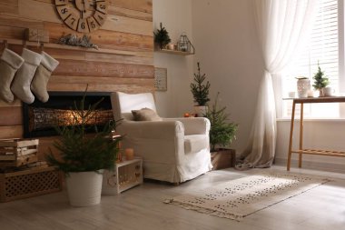 Odasında şömineli köknar ağaçları ve Noel süsleri vardı. Şık iç tasarım