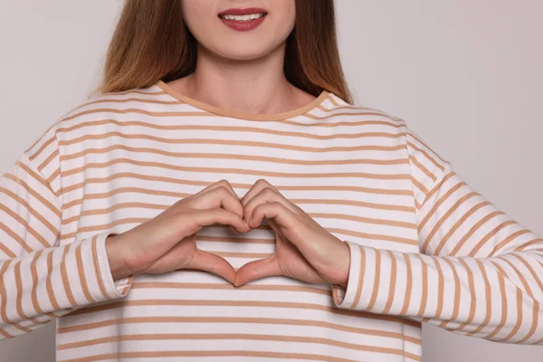 Young Woman Making Heart Hands Light Grey Background Closeup Volunteer — Stockfoto
