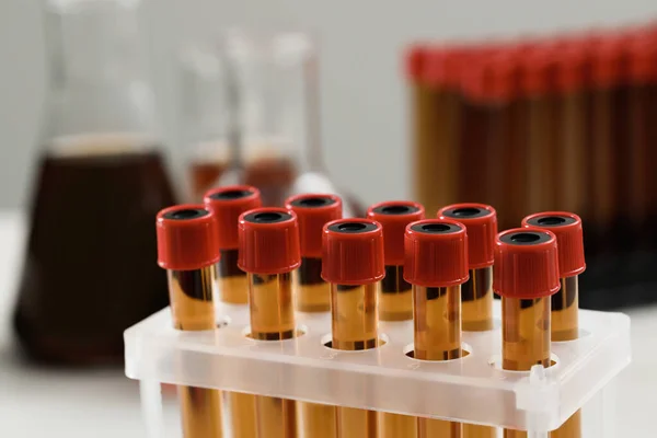 Test tubes with brown liquid in stand, closeup