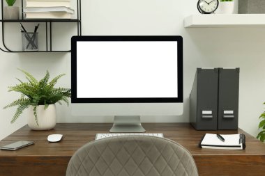 Comfortable workplace at home. Modern computer with blank screen and stationery on wooden desk. Mockup for design