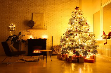 Beautiful Christmas tree and gifts near fireplace in room. Interior design