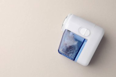 Modern fabric shaver with fuzz on white background, top view. Space for text