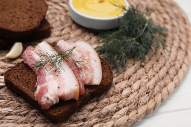 Sandwich with pork fatback on wicker mat, closeup