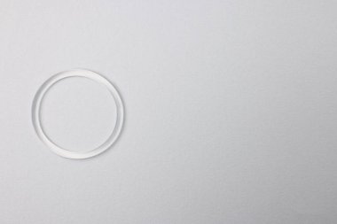 Diaphragm vaginal contraceptive ring on grey background, top view. Space for text