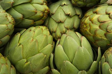 Arka plan olarak pek çok taze çiğ enginar, üst görünüm