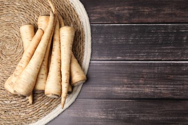 Whole raw parsley roots on wooden table, flat lay. Space for text
