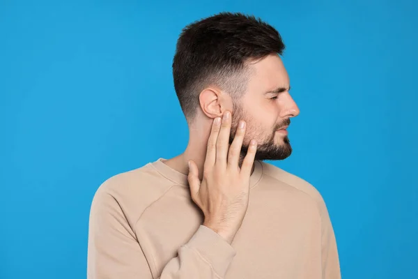 Young Man Suffering Ear Pain Light Blue Background — Photo
