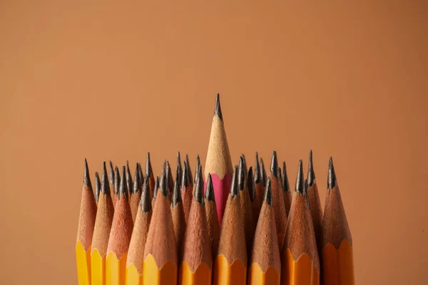 Many sharp graphite pencils on brown background