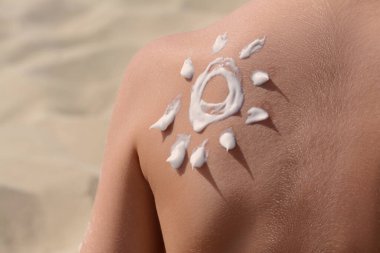 Sahilde güneş kremiyle çocuğun sırtına çizilmiş, yakın plan.