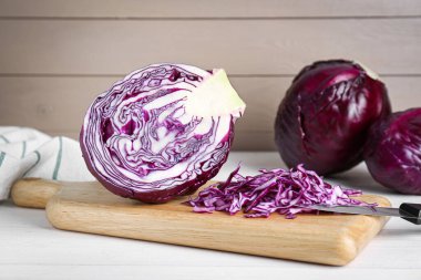 Cut fresh red cabbage on white wooden table