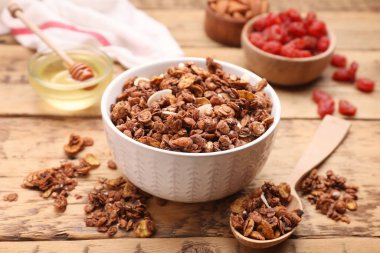 Tasty granola served with nuts and dry fruits on wooden table