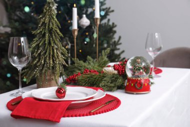Luxury place setting with beautiful festive decor for Christmas dinner on white table. Space for text