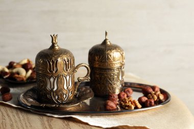 Çay ve fındık, ahşap masada çay seti içinde servis edilir, metin için yer vardır.