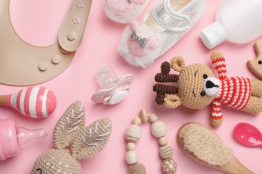 Flat lay composition with pacifier and other baby stuff on pink background