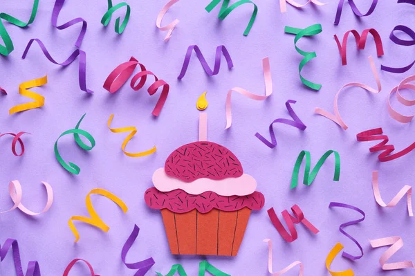 Birthday party. Paper cupcake and confetti on lilac background, flat lay