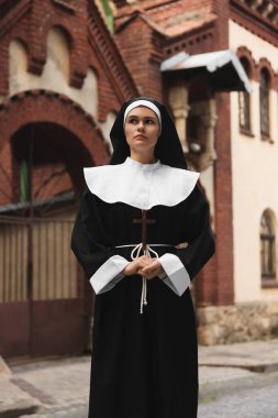 Hristiyan haçı olan genç rahibe bina yakınlarında.