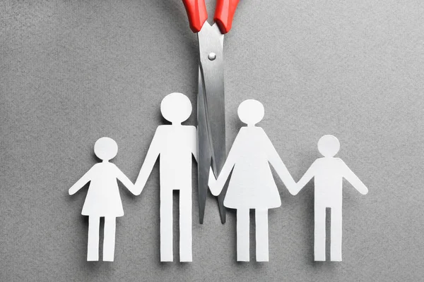 Divorce concept. Paper cutout of family and scissors on light grey background, flat lay