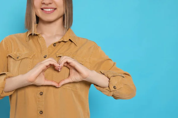 Young Woman Making Heart Hands Turquoise Background Space Text Volunteer — Stockfoto