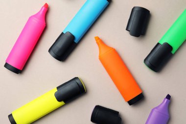 Bright color markers on light grey background, flat lay