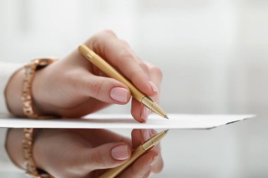 Cam masada kağıda yazı yazan kadın, yakın plan.
