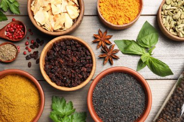 Gri ahşap masada farklı baharatlarla bezenmiş düz bir kompozisyon.