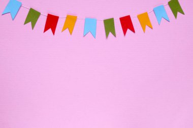 Pembe arka planda renkli bayraklar, düz yatış. Metin için boşluk