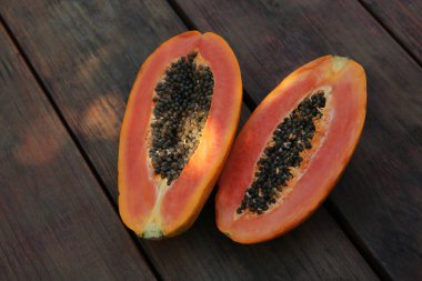 Fresh ripe cut papaya fruit on wooden table, flat lay
